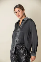 Camisa color crema de satén italiano con cuello clásico, cierre frontal con botones y mangas largas. Presenta apliques de strass en cuello, solapa y puños.