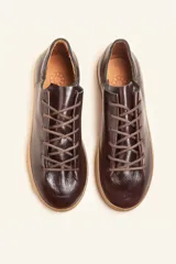 Zapatilla de cuero vacuno color azul marino, con cordones azules y suela de caucho color caramelo.