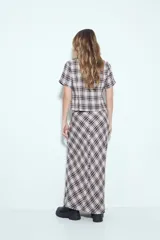 Falda larga de silueta fluida con estampado a cuadros en tonos marrones y beige. La prenda tiene una caída liviana y un calce cómodo.