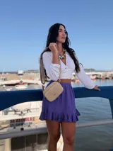 Bandolera de símil cuero color verde oliva, con diseño de dos compartimentos con cierre y correa ajustable de tela con patrón geométrico.