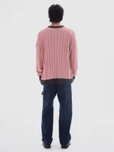 Buzo tejido de ochos color rosado, con cuello a la base y rayas contratono en puños y cuello.