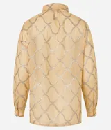 Camisa color dorado con estampado geométrico plateado, de manga larga con puños abotonados, cuello camisero y cierre frontal con botones ocultos.