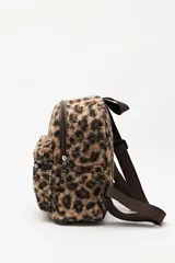 Mochila compacta con estampado animal print de textura suave y esponjosa. Cuenta con un bolsillo frontal con cierre, correas ajustables y asa superior en color marrón.