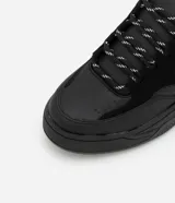 Championes masculinos negros de estilo urbano con suela bold, confeccionados en PU con detalles texturizados y atacadores bicolores.