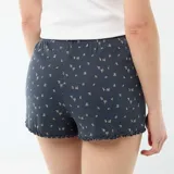 Pantalón corto de pijama azul marino de algodón con estampado de pequeñas flores blancas y detalles ondulados en el borde inferior.