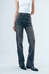 Pantalón de jean tiro alto con corte recto levemente acampanado. Presenta bolsillos delanteros tipo cargo marcados y costuras visibles en color marrón.