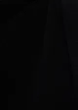 Vestido corto negro sin mangas, confeccionado en punto fino, con cuello barco y tirantes asimétricos.