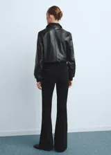 Jeans negros de corte flare, tiro medio y diseño clásico con bolsillos.