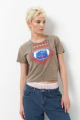 Remera negra de manga corta con estampa de escudo con la inscripción "Sports League" y una pelota de fútbol americano.