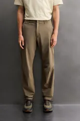 Pantalón técnico de corte regular fit en color marrón, confeccionado en tejido elástico y compacto. Cuenta con cintura ajustable con cordón interior, bolsillos frontales, bolsillo trasero con cierre oculto y bolsillo lateral con cierre en la pernera. El bajo es ajustable mediante botones a presión.