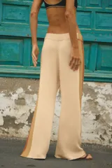 Pantalón tejido de corte amplio y tiro medio, con diseño de franjas laterales en tonos contrastantes marrón y beige. Posee cintura elástica y terminación de ruedo sin costura.