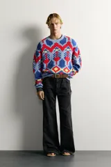Jersey de punto tejido en hilatura de algodón, con diseño de patrones geométricos en colores celeste, azul, rojo y amarillo. Presenta cuello redondo, manga larga y acabados en rib.