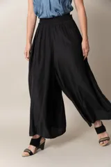 Pantalón ancho de seda color negro, con cintura elastizada y caída fluida.