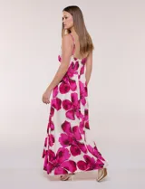 Vestido maxi de fondo blanco con estampado de flores grandes en tonos verde y marrón, con escote en V, breteles finos y detalle de abertura cut-out en el centro del busto.