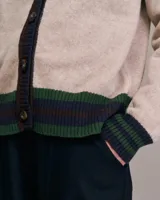 Cárdigan de punto color beige con mangas largas y ribetes en marrón, azul y verde.