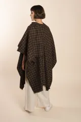 Ruana de lana fina color crudo con terminación envivada.