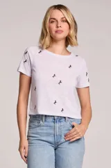 Remera blanca de lino con estampado de pequeños caballos, cuello redondo y mangas cortas.