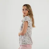 Blusa azul con estampado de flores blancas, cuello redondo y mangas cortas con volados.