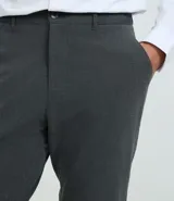 Pantalón de corte slim para hombre, confeccionado en tejido de poliéster, viscosa y elastano. Presenta cintura elástica con trabillas para cinturón, cierre tradicional y bolsillos funcionales.