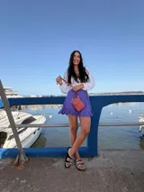 Bandolera pequeña tipo porta celular, color verde claro, confeccionada en cuero sintético. Cuenta con cierre principal, bolsillo frontal con tapa y broche a presión, y correa ajustable extraíble.