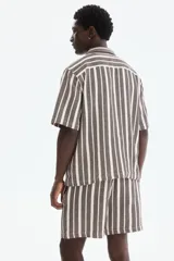 Short de corte regular fit en tejido texturizado con mezcla de algodón, con diseño de rayas verticales en tonos marrón y crudo. Cuenta con cintura elástica ajustable con cordón y bolsillos laterales.