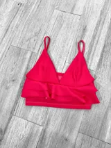 Top color rosa con breteles finos, escote en V y doble volado en el ruedo.