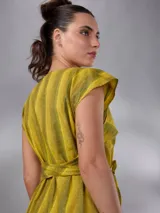 Vestido largo de lino y algodón con diseño de rayas verticales en tonos mostaza y verde. Presenta escote en V, cuello solapa ancho, mangas cortas con diseño capa, corte recto y lazo ajustable en la cintura.