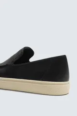 Mocasín casual de cuero negro con detalle de costuras en el empeine y suela de goma color crema.