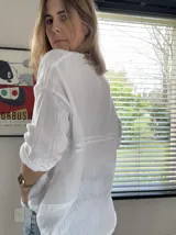 Camisa de manga larga de bambula de algodón, color blanco, con cuello mao, apliques de encaje en la pechera y botones frontales de coco. Diseño holgado.