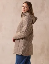 Campera capitoneada de corte largo con diseño acolchado en forma de rombos. Cuenta con cierre frontal completo, capucha desmontable, bolsillos delanteros con solapa y cierre, y forro interno a tono.