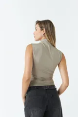 Top sin mangas de cuello alto, confeccionado en tejido liviano y suave con ajuste al cuerpo.