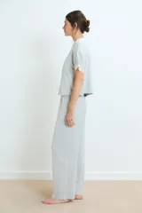 Pijama de dos piezas en color gris melange, compuesto por una remera de manga corta con detalles de encaje en los bordes y un pantalón de corte recto con cintura elástica y detalle de encaje en la pretina.