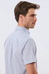 Camisa de manga corta con microcuadros en tonos celestes y blancos, calce slim, cuello con botones y bolsillo frontal con logo bordado.