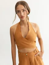Top tipo halter color tostado, con diseño cruzado en el frente y espalda descubierta.