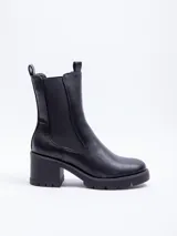 Bota tipo Chelsea de caña alta confeccionada en cuero sintético, con paneles elásticos laterales y suela track con plataforma.