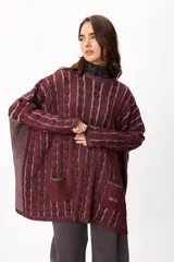 Sweater de tejido artesanal con diseño de rayas verticales en tonos camel y beige, corte holgado, cuello redondo y puños altos ajustados.