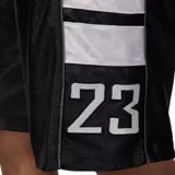 Short deportivo Nike Jordan modelo Brooklyn CAT Scratch, de color negro con detalles en blanco. Presenta bandas laterales con bloques blancos y el número 23 estampado en la parte inferior de la pierna. Cuenta con cintura elástica con el logotipo de Jordan.