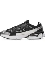 Championes deportivos Under Armour modelo Sola, con diseño futurista en color negro, detalles plateados y suela blanca. Presentan parte superior ligera con superposiciones, refuerzo de TPU en el talón y entresuela de EVA acolchada.