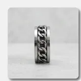 Anillo de acero italiano con diseño giratorio que presenta un motivo de cadena central.