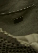 Bolso tipo tote en color verde militar, con diseño tejido de efecto natural y doble asa de mano.