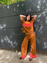 Sweater marrón de tejido de punto con una franja horizontal roja en el pecho y mangas cortas abullonadas.