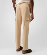 Pantalón cargo de corte recto en color beige, confeccionado en tejido de sarga de algodón. Cuenta con bolsillos laterales y bolsillos cargo con solapa en las piernas, cintura con pasacintos y cierre frontal con botón y cremallera.
