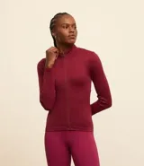 Campera deportiva color bordó, de corte ajustado, confeccionada en malla de poliamida seamless y con cuello alto. Posee textura acanalada y cierre delantero por cremallera.