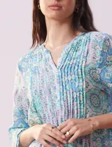 Blusa de gasa estampada con cuello a la base, escote en V, botones y manga ¾ amplia.