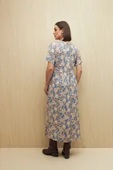 Vestido largo celeste con estampado floral en tonos beige y marrón, escote en V con botones al frente, mangas cortas y falda con leve vuelo. Confeccionado en viscosa liviana.