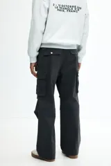 Pantalón cargo gris oscuro de corte holgado, con cintura elástica y bolsillos laterales, traseros y tipo cargo con solapa y botón a presión.