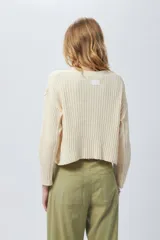 Sweater color crema de tejido de punto acanalado, corte cropped, cuello redondo y mangas largas.