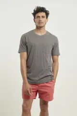 Remera gris con bolsillo ojal en el pecho, de manga corta y cuello redondo.