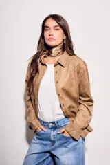 Camisa color marrón de gamuza sintética, de corte recto, con cuello clásico, cierre frontal con botones y mangas largas.