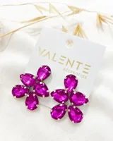 Par de aros colgantes con forma de flor, compuestos por cinco cristales fucsia en forma de lágrima engarzados en metal plateado.